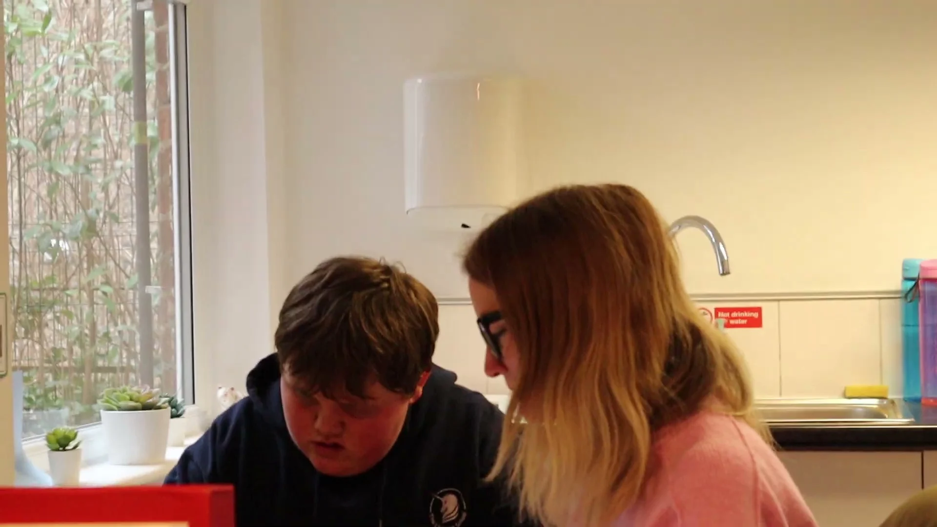 Two pupils working side by side at a classroom table